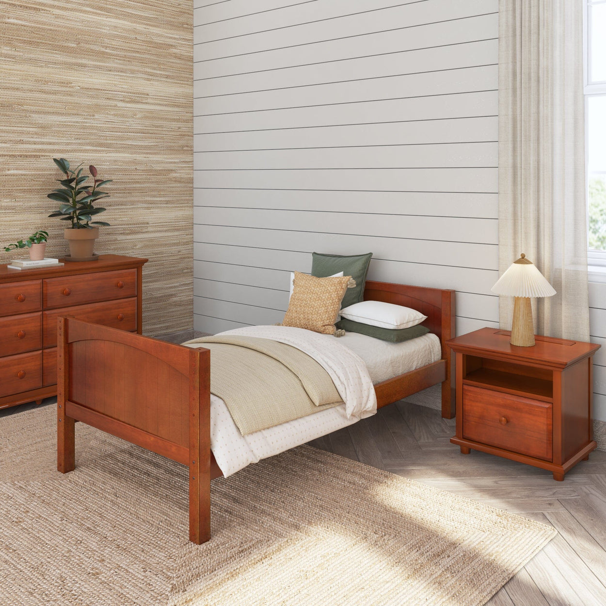 Cozy bedroom with wooden single bed, dresser, and nightstand, featuring neutral bedding and a potted plant for a warm, inviting atmosphere.