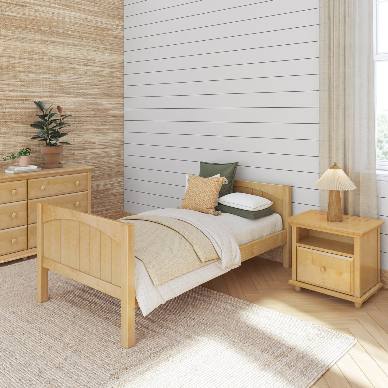 Modern minimalist bedroom with wooden furniture, featuring a cozy bed, dresser, and nightstand on wooden flooring.