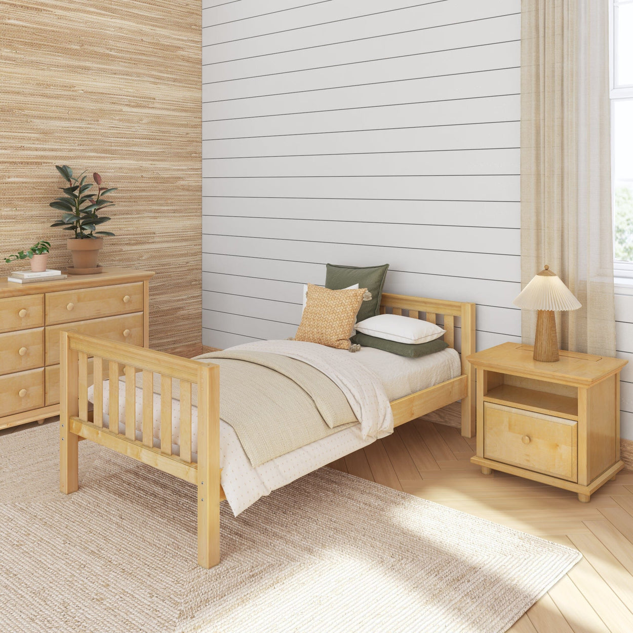 Cozy bedroom with wooden furniture, single bed, nightstand, and dresser, featuring neutral tones and indoor plant.