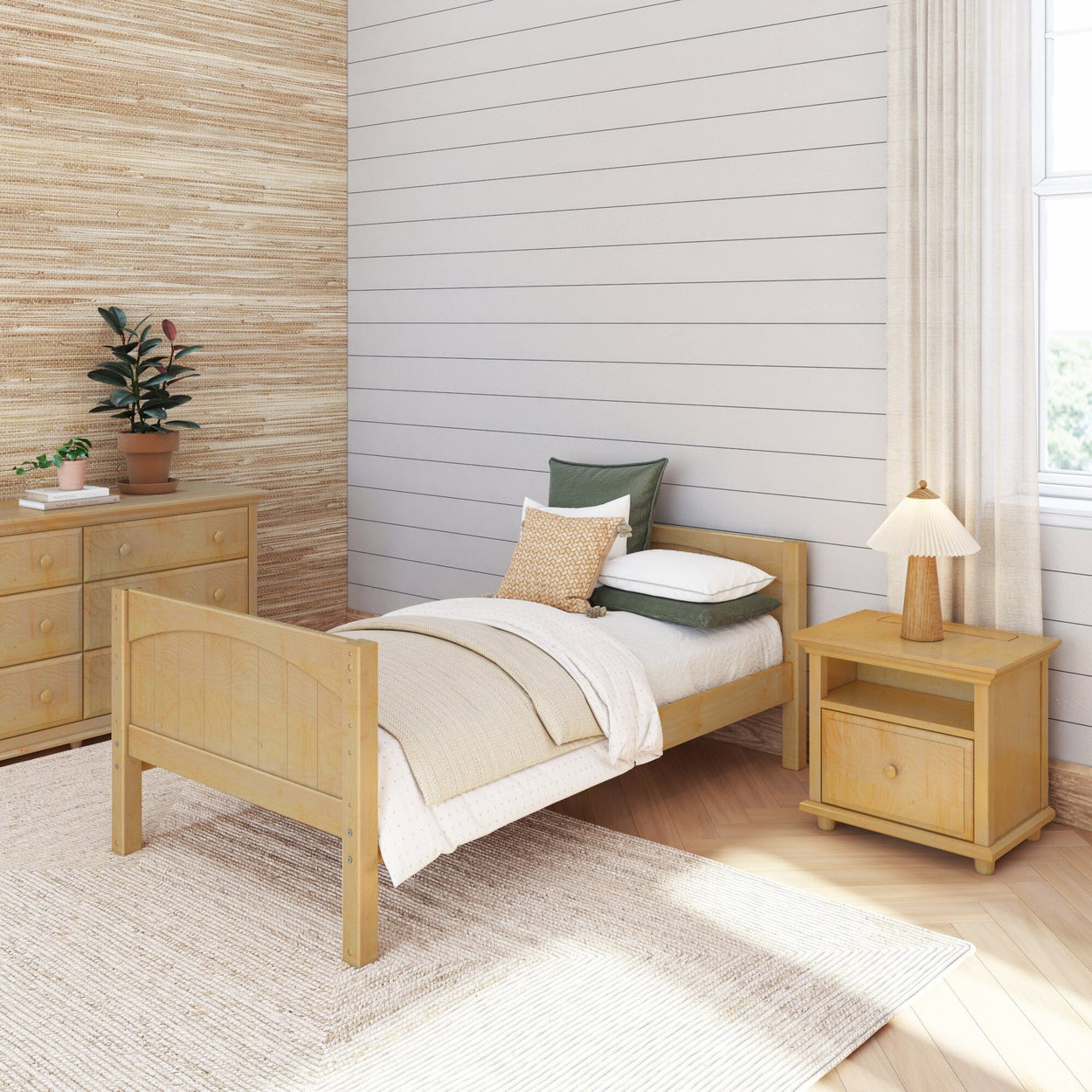Cozy minimalist bedroom with wooden single bed, nightstand, and dresser, featuring natural decor and soft lighting.