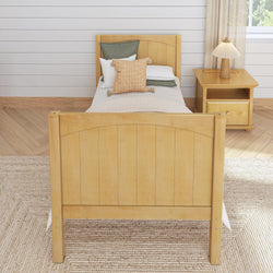 Single wooden bed in a cozy room with nightstand and decorative pillows.