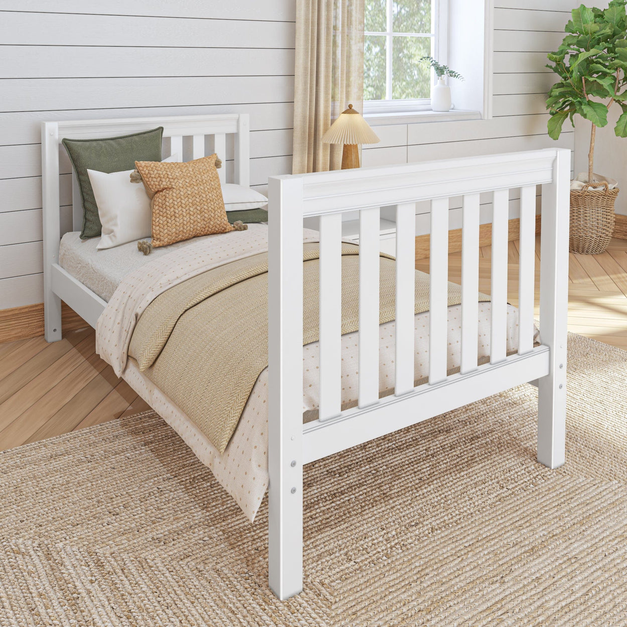 White wooden twin bed with cozy bedding in a modern farmhouse bedroom with shiplap walls and natural light.
