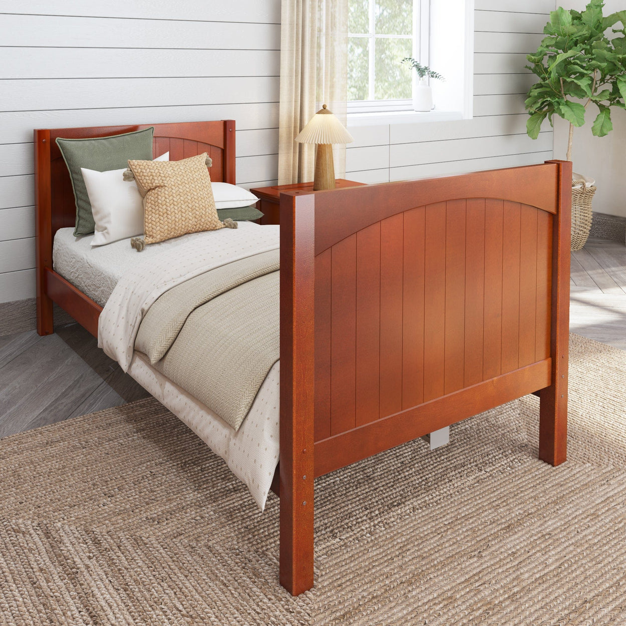 Cherry wood twin bed with cozy bedding and decorative pillows in a rustic bedroom.