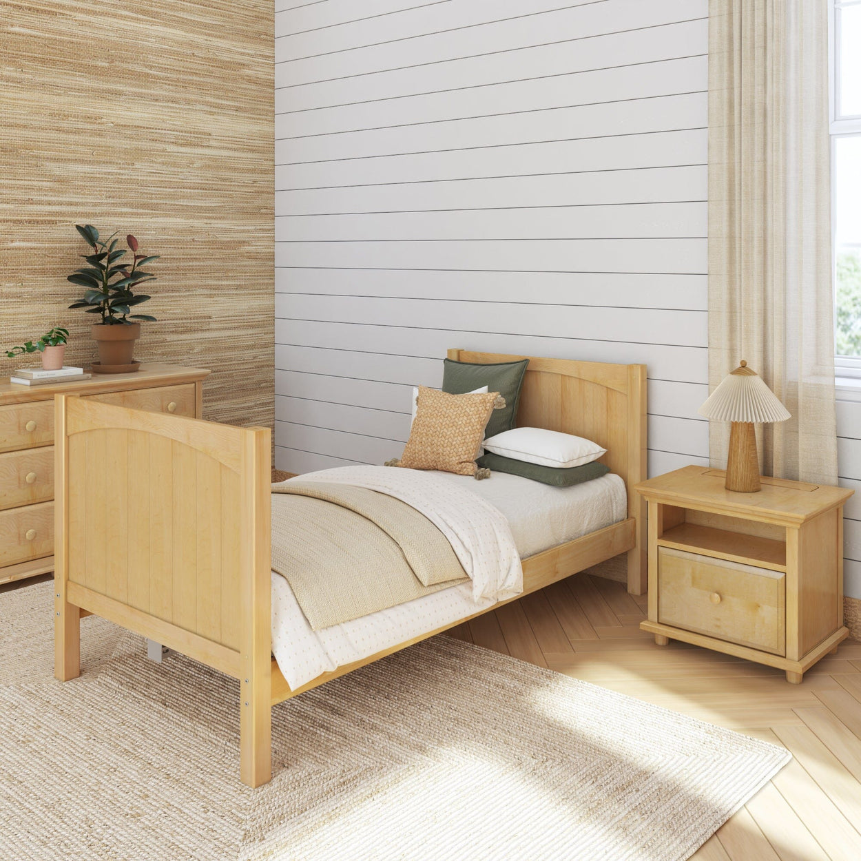 Cozy minimalist bedroom with wooden single bed, nightstand, and dresser, beige bedding, and potted plant décor.