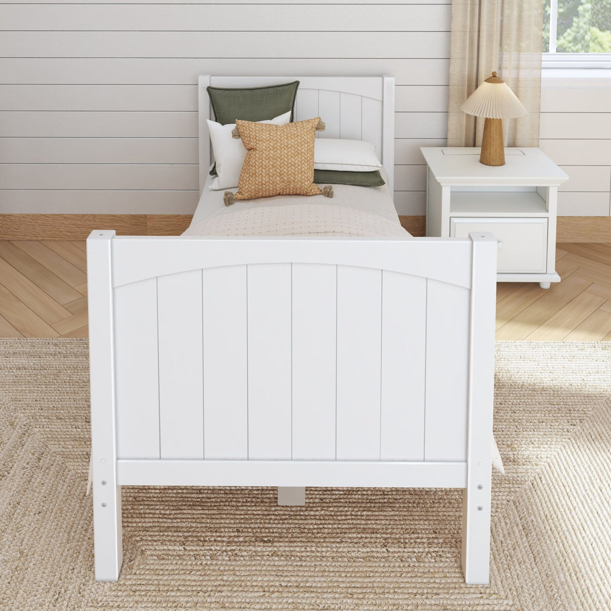 Cozy bedroom with white modern twin bed, green and tan pillows, and wooden nightstand, ideal for stylish home decor.