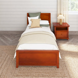 Single wooden bed with cozy bedding and nightstand in a stylish modern bedroom interior.