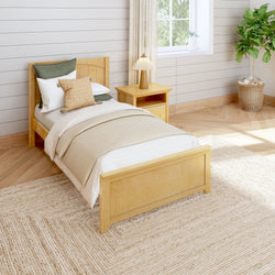 Cozy bedroom with wooden single bed, green and beige pillows, matching nightstand, and indoor plant by the window.