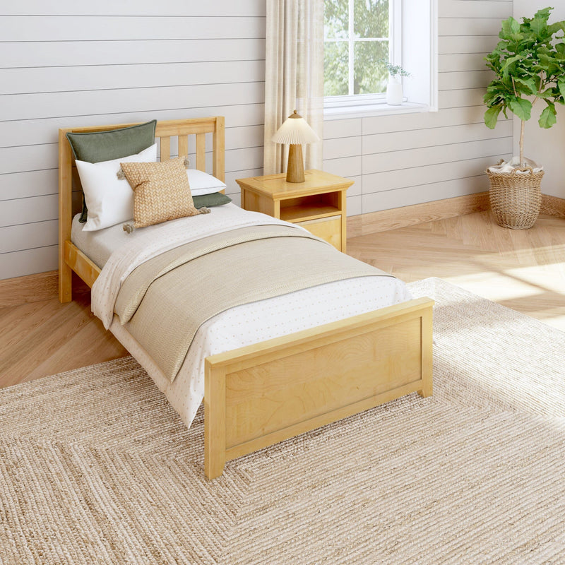 Cozy modern farmhouse bedroom with natural wood single bed, neutral linen bedding and knit throw, green accent pillows, wooden nightstand with lamp, jute rug, shiplap walls and potted fiddle leaf fig by a sunlit window
