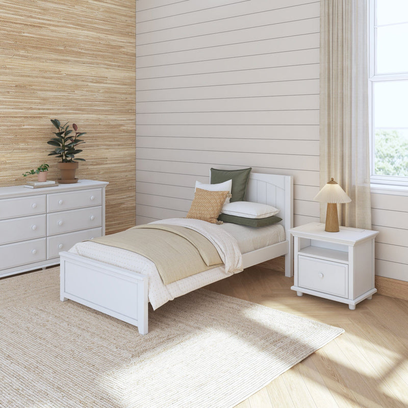 Cozy neutral bedroom with white wooden twin bed, beige shiplap and woven grasscloth accent wall, white dresser, textured rug, potted plants and natural light