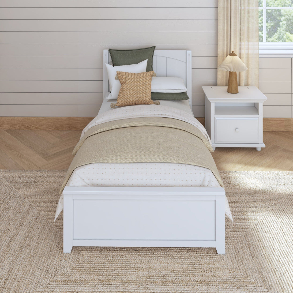 White twin bed with beige blanket and pillows in a modern bedroom with wooden nightstand and lamp.