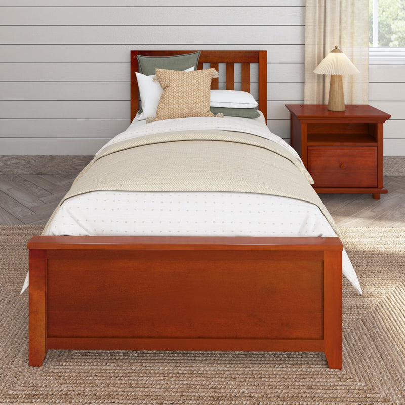 Wooden twin bed with textured beige throw pillow and layered neutral bedding beside a cherry nightstand with pleated lamp against white shiplap wall, modern farmhouse bedroom
