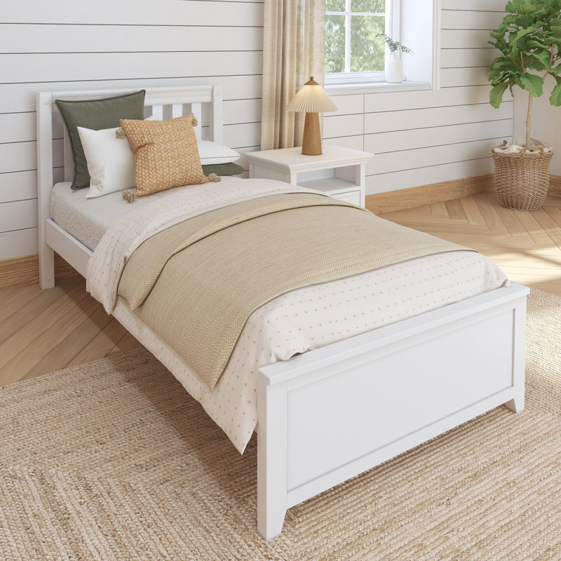 Cozy neutral farmhouse bedroom with white wooden bed, layered beige bedding and throws, textured woven pillows, bedside table lamp, jute rug and potted fiddle leaf fig plant, modern coastal farmhouse interior