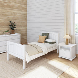 Cozy farmhouse bedroom with white wooden bed, neutral bedding, rustic wood panel wall, and natural fiber rug.