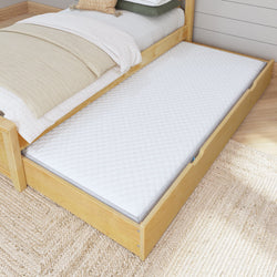 Wooden bed frame with pull-out trundle bed and white mattress in cozy bedroom setting.