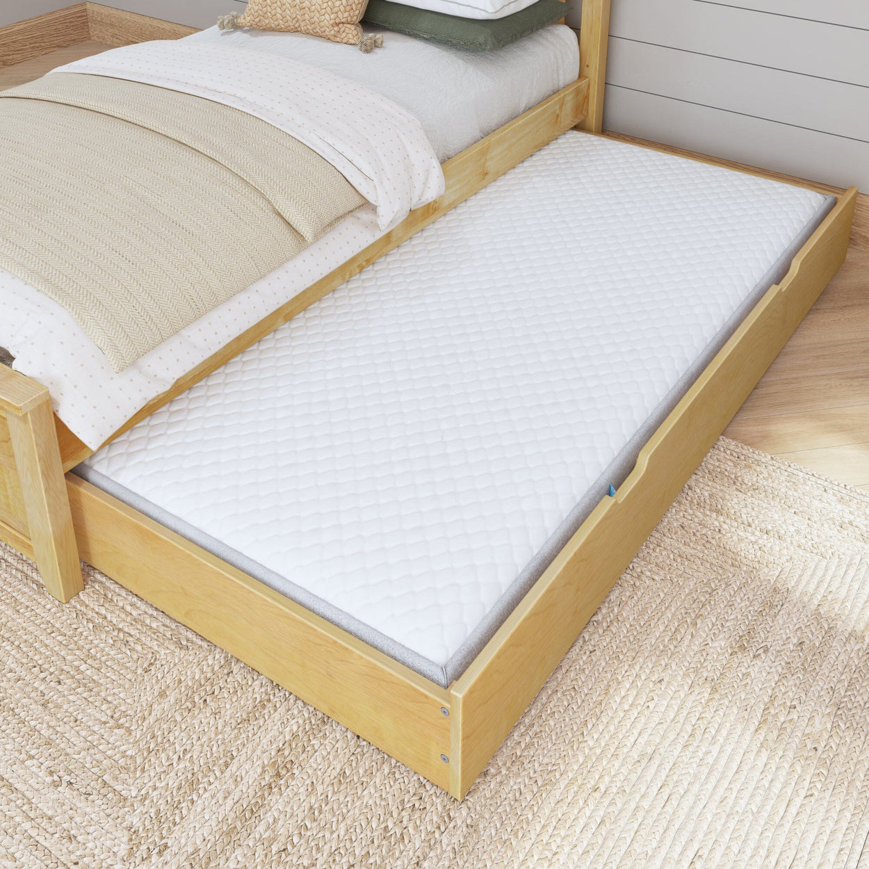 Wooden bed frame with pull-out trundle bed featuring a comfortable white mattress, ideal for maximizing bedroom space.