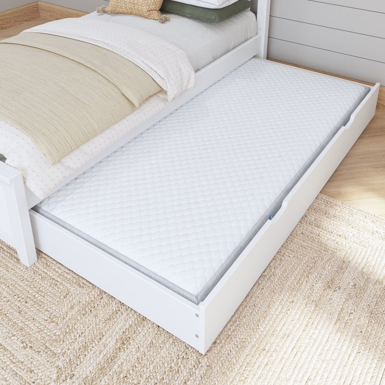 White trundle bed with comfortable mattress in modern bedroom setting.