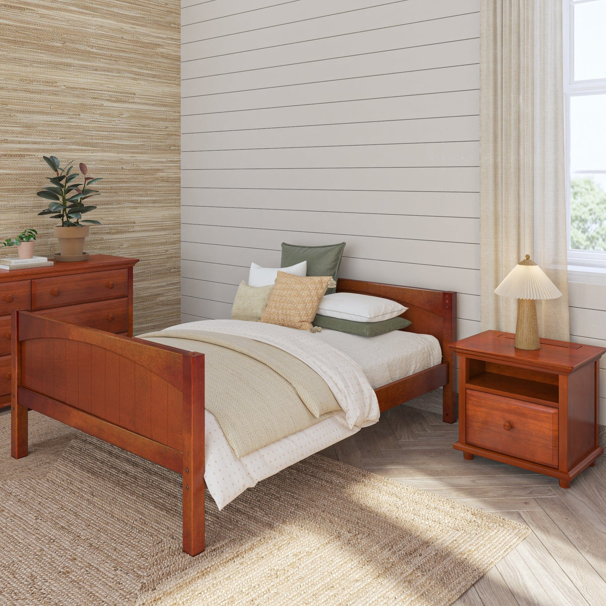 Cozy bedroom with wooden bed, bedside table, and dresser, featuring earth-toned bedding and decor.