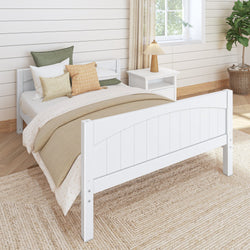 Wooden bed frame in cozy bedroom with white nightstand and beige rug.