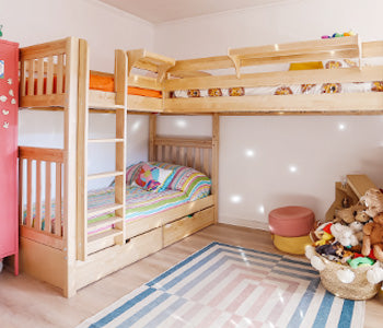 Cozy modern bedroom with white storage platform bed featuring under-bed cubbies, blue quilt and striped pillows, leather-look accent pillow, wooden oar wall decor and light hardwood floor