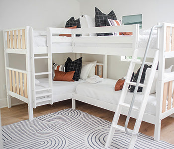 Light wood dresser with an open drawer filled with folded white towels, coastal bedroom decor featuring a decorative knot sculpture and ocean art print