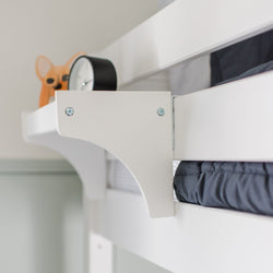 White loft bed with a functional shelf holding a black alarm clock and decorative item.