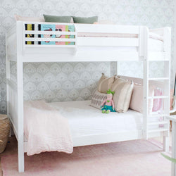 White bunk bed with pastel bedding and children's books in a stylishly decorated kids' bedroom.