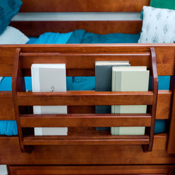 Wooden bed frame with built-in book storage holding books, in a cozy bedroom setting.