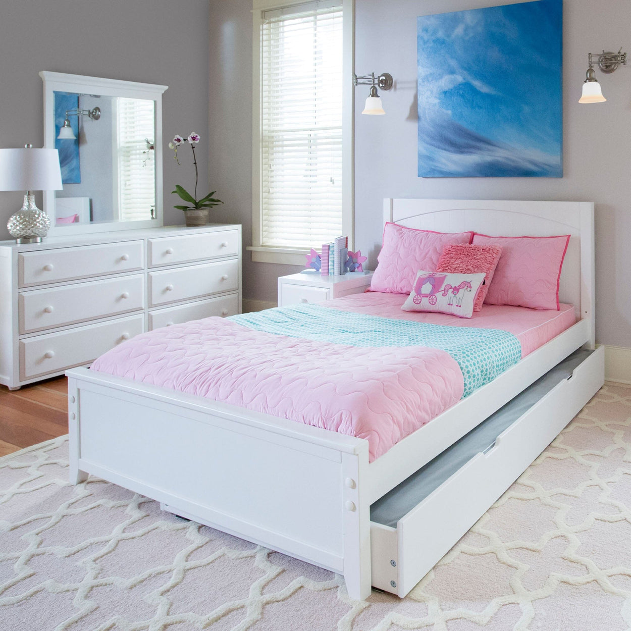 White children's bedroom with pink bedding, decorative pillows, and modern furnishings.