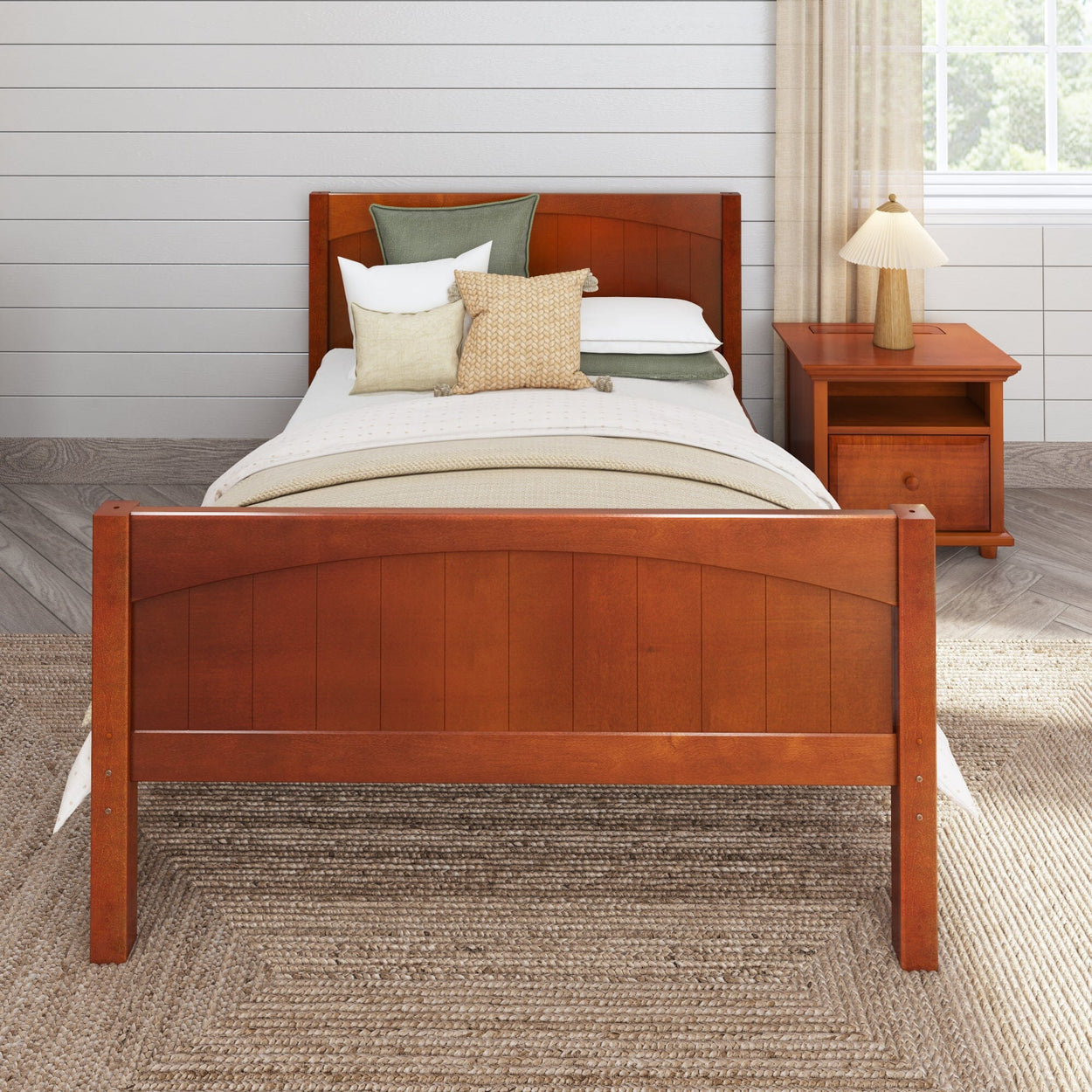 Wooden bed frame with white bedding and decorative pillows in a cozy bedroom setting with a bedside table and neutral decor.