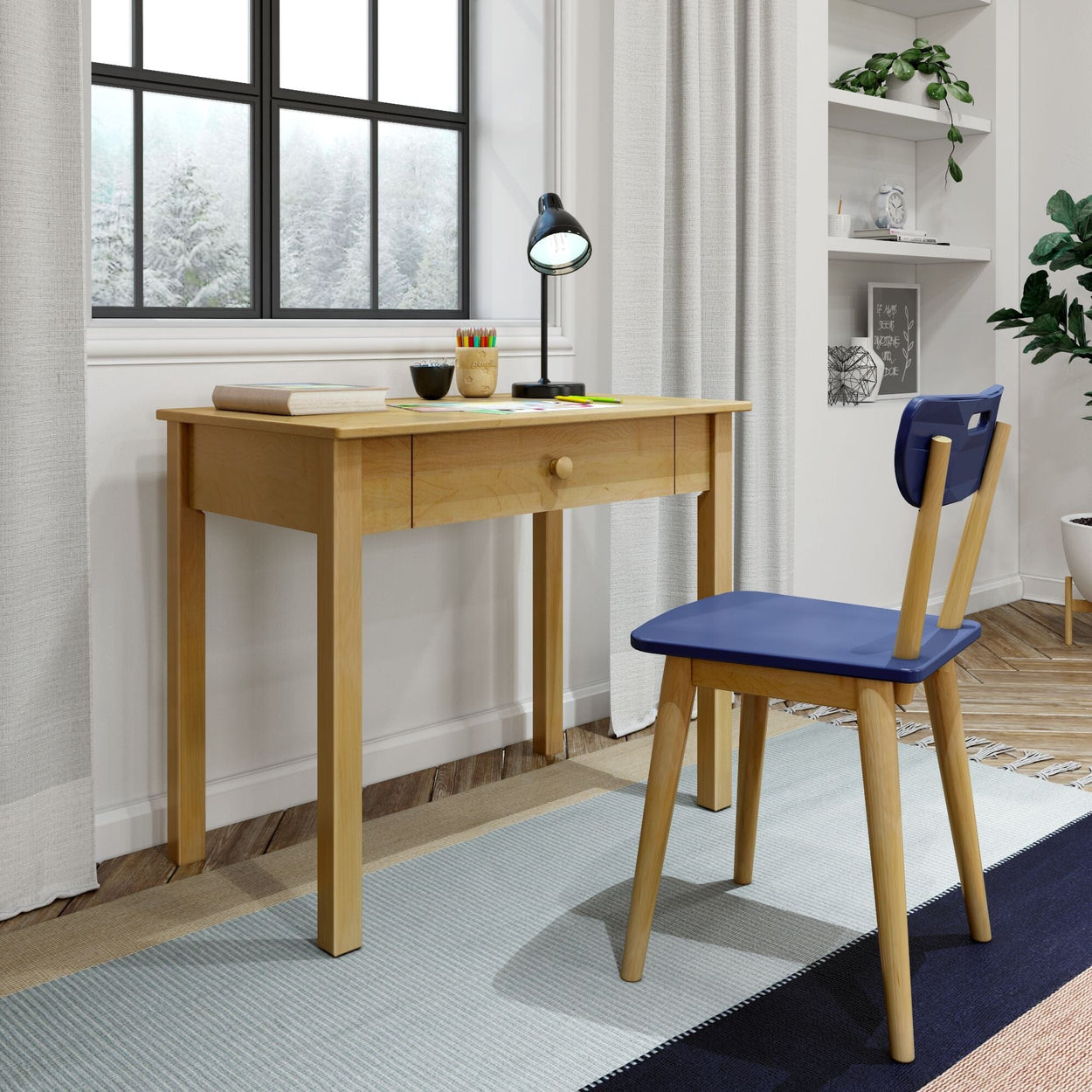 Wooden study desk and chair with blue cushion in a modern home office setup near a window with a scenic view.