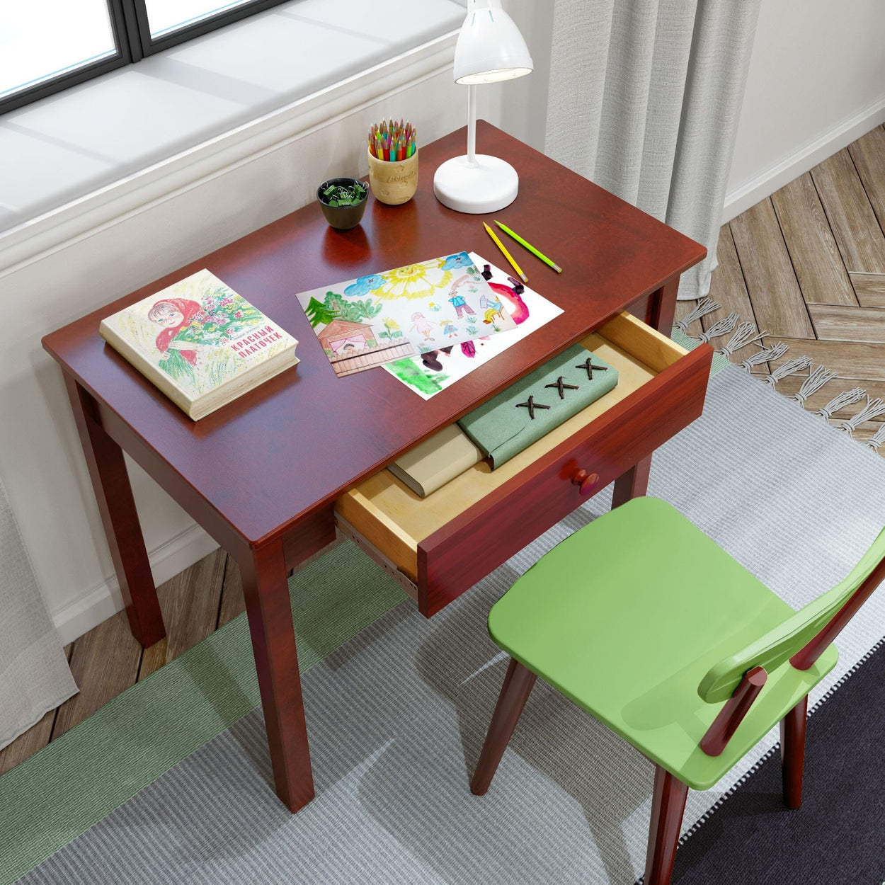 Children's study desk with drawing paper and colored pencils, featuring a wooden chair and open drawer, perfect for creative activities.