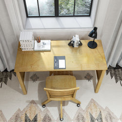 Wooden desk setup by a window with books, a lamp, and a chair, ideal for home office organization and productivity.
