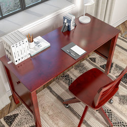 Cherry wood desk with office chair and stationery in a bright home office setting.