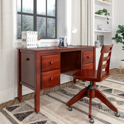 Wooden office desk and chair in cozy home office setup with books, lamp, and window view.