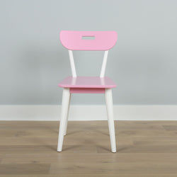 Pink and white modern children's chair on wooden floor against a light gray wall.