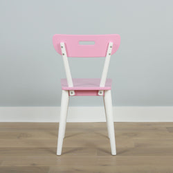 Pink and white children's chair with a modern design against a gray wall background on a wooden floor.