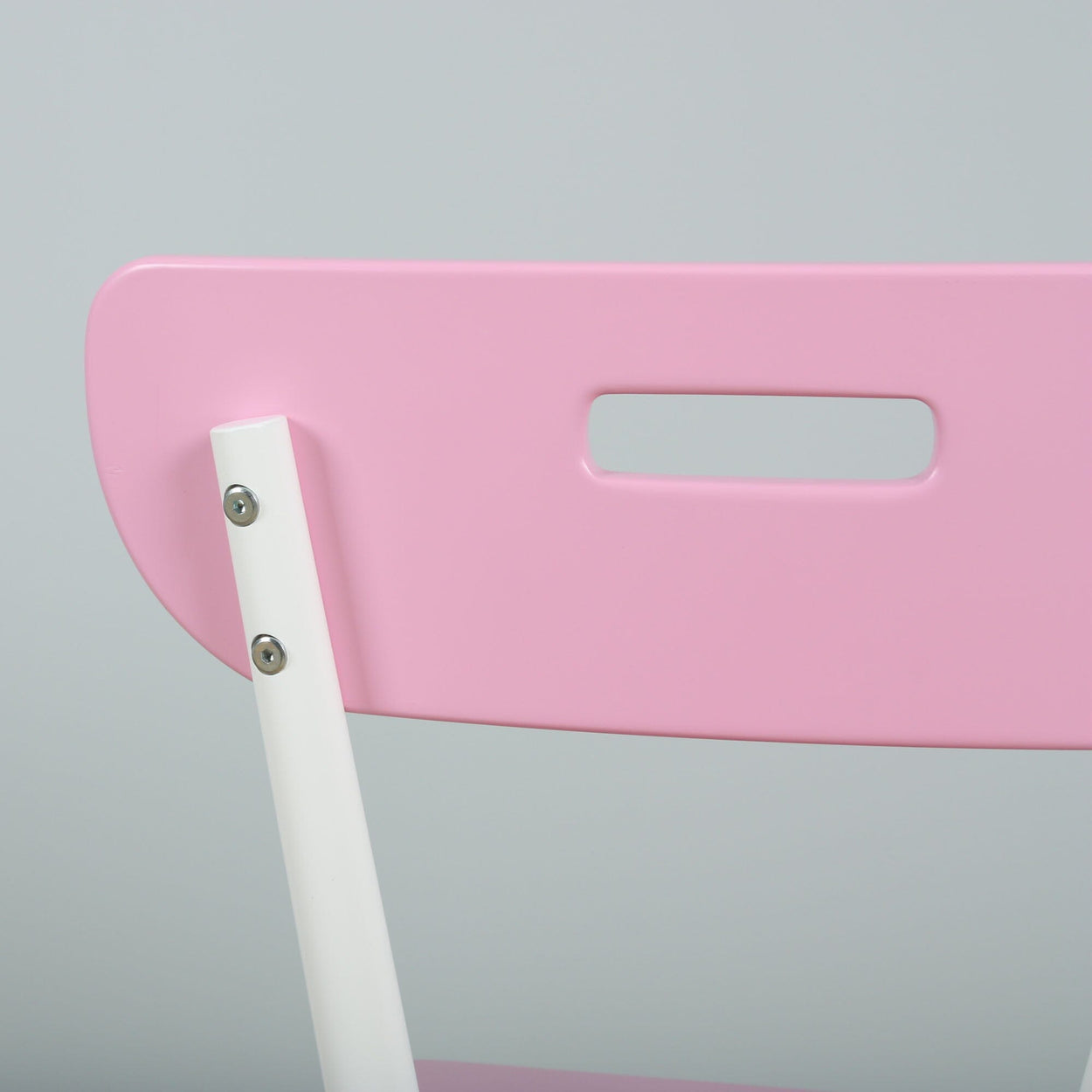 Pink folding chair with white frame and modern design, close-up view.