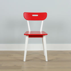 Red and white modern dining chair on wooden floor against a light gray wall.