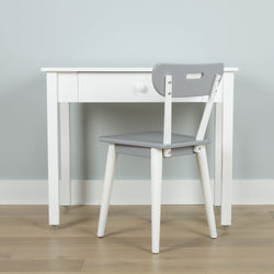 White desk with a single drawer paired with a gray chair on a wooden floor, ideal for minimalist home office setup.