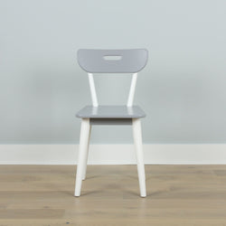 Gray and white minimalist chair on wooden floor against light gray wall, modern interior design.