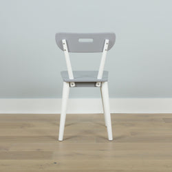 Gray and white modern chair with a sleek design placed on a wooden floor against a light gray wall.