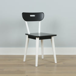 Modern black and white wooden chair on a light wooden floor.