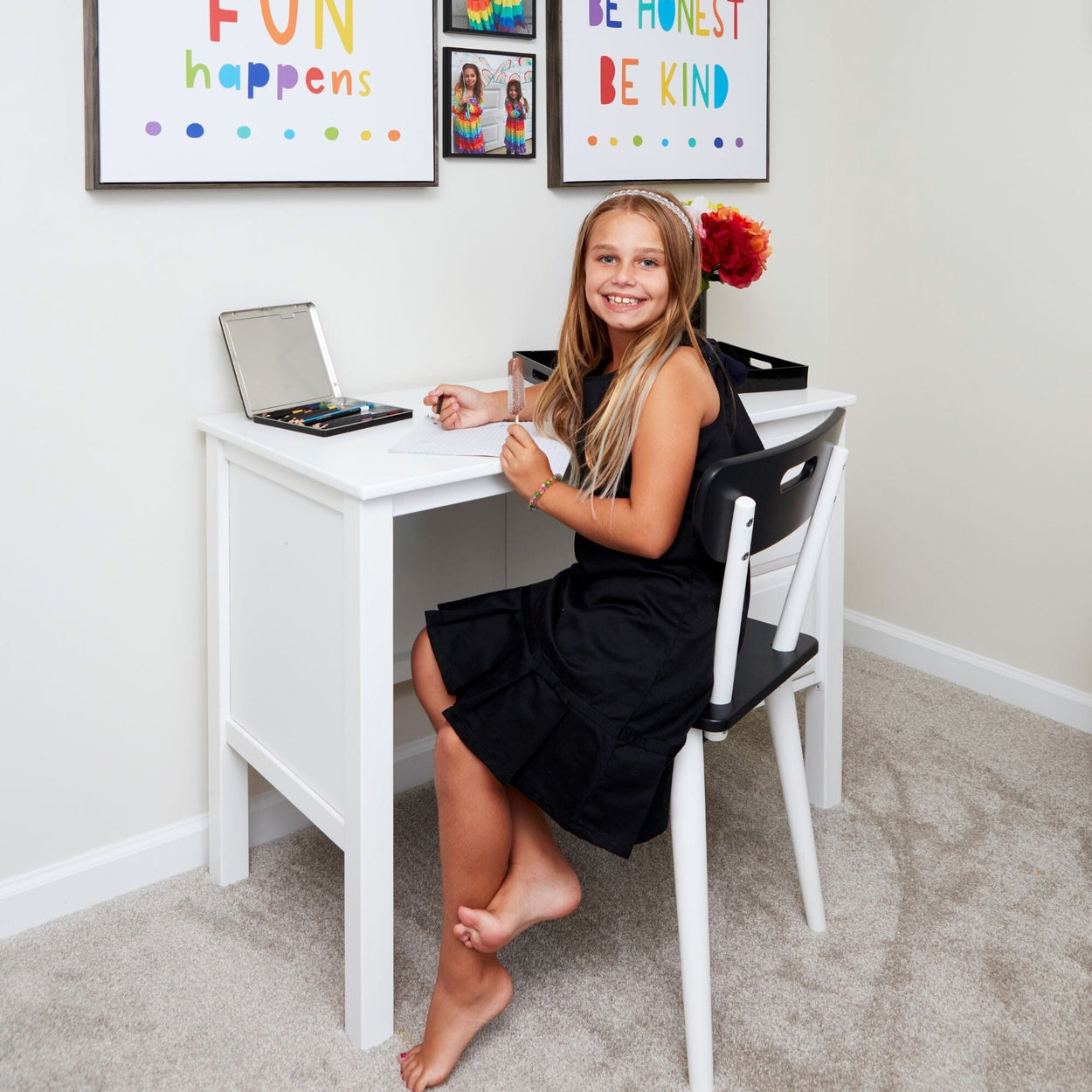 Schoolgirl doing homework at desk with motivational wall art.