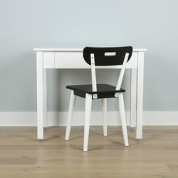 Minimalist black and white desk and chair set on wooden floor.
