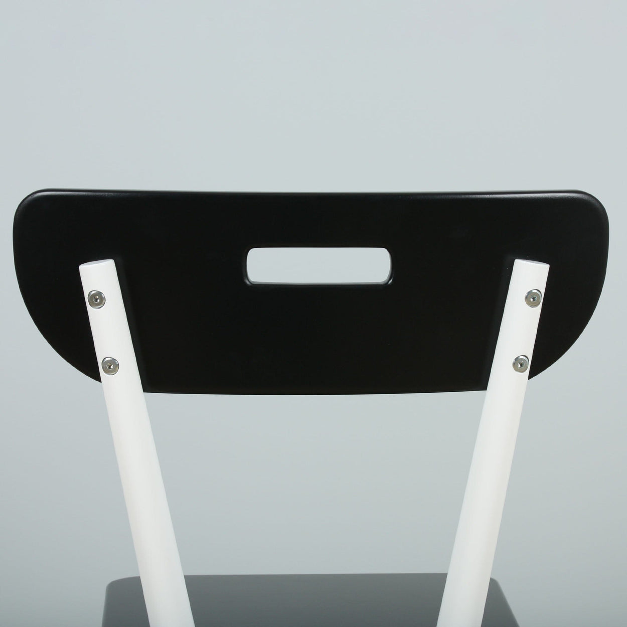 Modern black and white chair with unique backrest design.