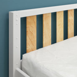White and wooden slatted bed frame with blue wall background, showcasing modern bedroom design.