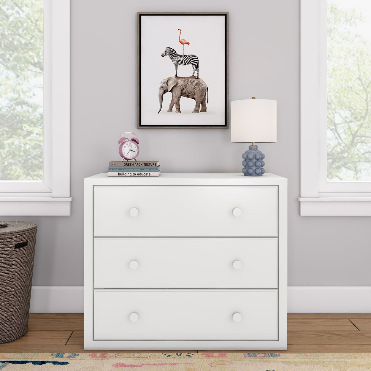 Elegant white dresser with a quirky animal art frame, featuring a lamp and clock, in a modern room setting.