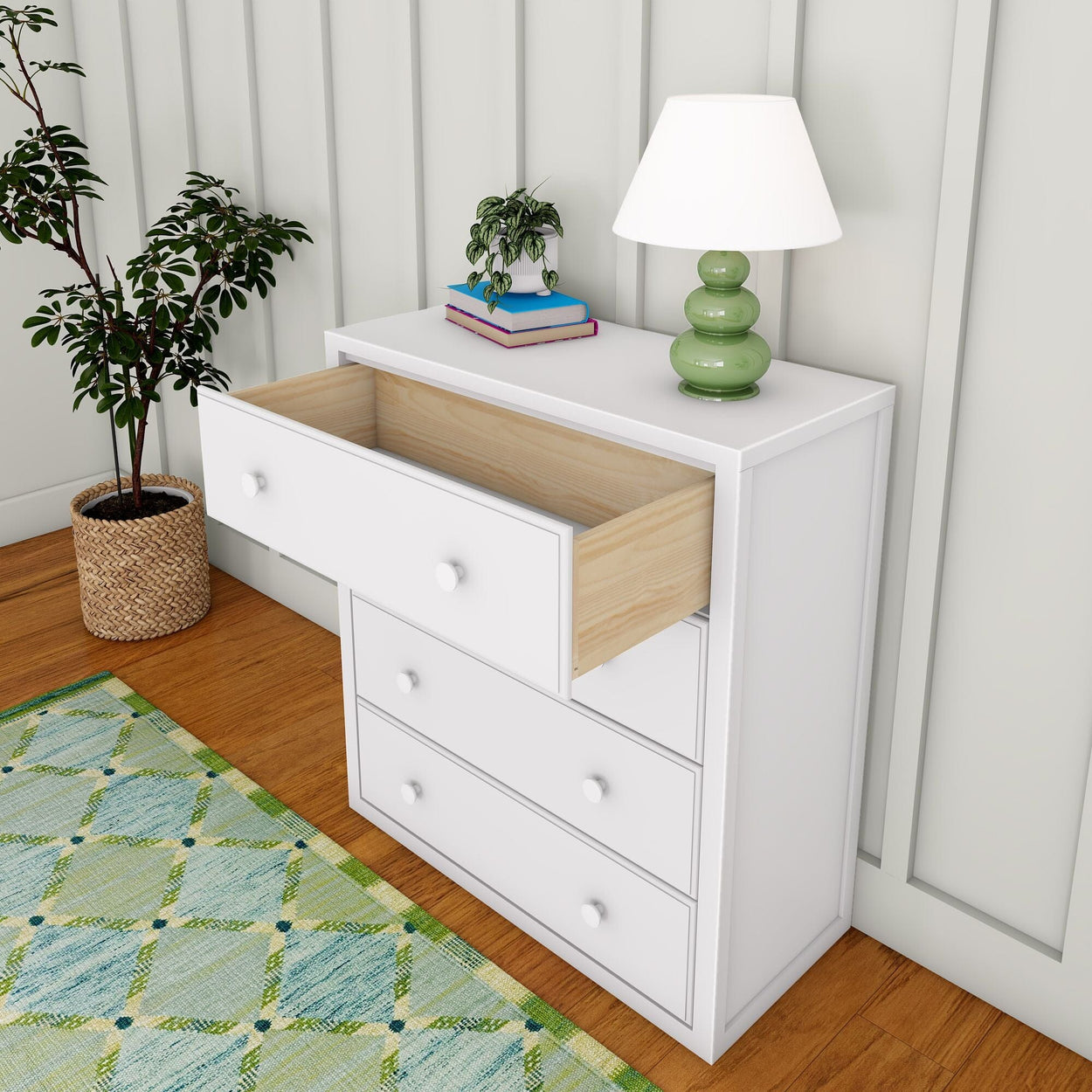 White bedroom dresser with open drawer, green lamp, and potted plant on hardwood floor.