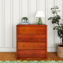 Modern wooden dresser with four drawers in a cozy room featuring a green lamp and potted plant.