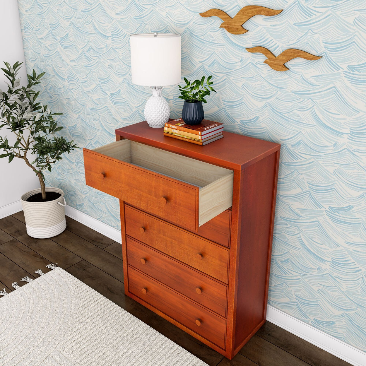 Wooden dresser with open drawer and decorative items, featuring a patterned wall background and potted plant.